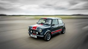 A gray-and-red David Brown Automotive Mini Remastered Oselli Edition goes around a track