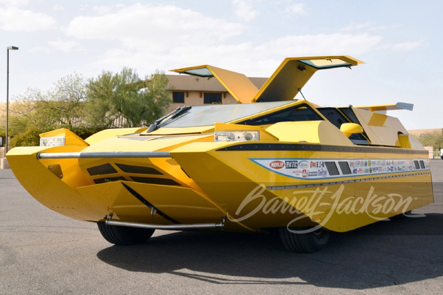 The yellow Dobbertin Hydrocar with its doors open parked in a parking lot