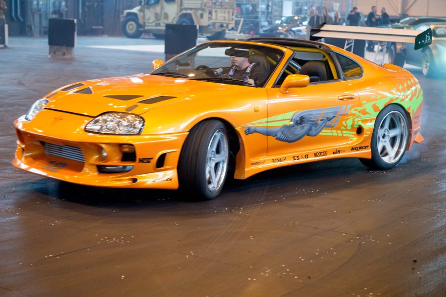 A yellow Toyota Supra coupe performing Fast and Furious Live