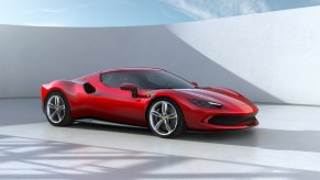 A red Ferrari 296 GTB parked by a white wall