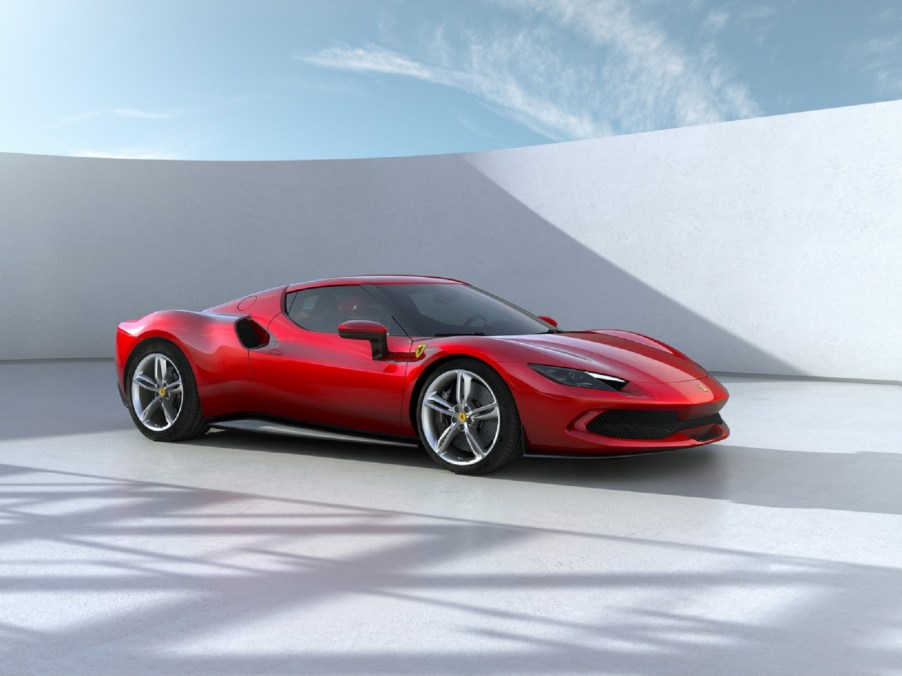 A red Ferrari 296 GTB parked by a white wall