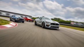 A white 2021 Ford Mustang Mach 1 on the track with older versions of the model