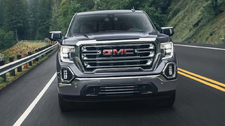 A gray 2021 GMC Sierra 1500 drives down a street.