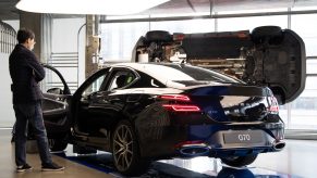 A customer wearing a protective mask looks at a Hyundai Motor Co. Genesis G70 sedan at the company's Motorstudio showroom in Seoul, South Korea