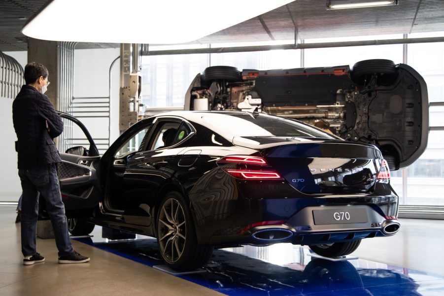 A customer wearing a protective mask looks at a Hyundai Motor Co. Genesis G70 sedan at the company's Motorstudio showroom in Seoul, South Korea