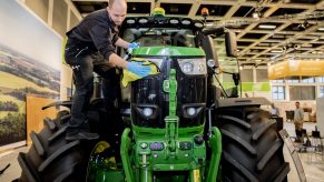 a man cleaning the front end of a new John Deere tractor