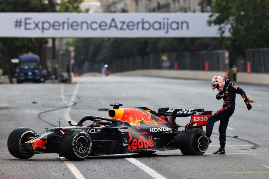 Max Verstappen kicks his Pirelli tires in frustration after crashing out due to a tire failure