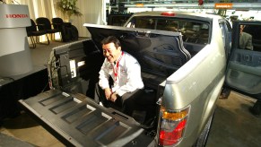 A man sits in the bed of the Honda Ridgeline pickup truck