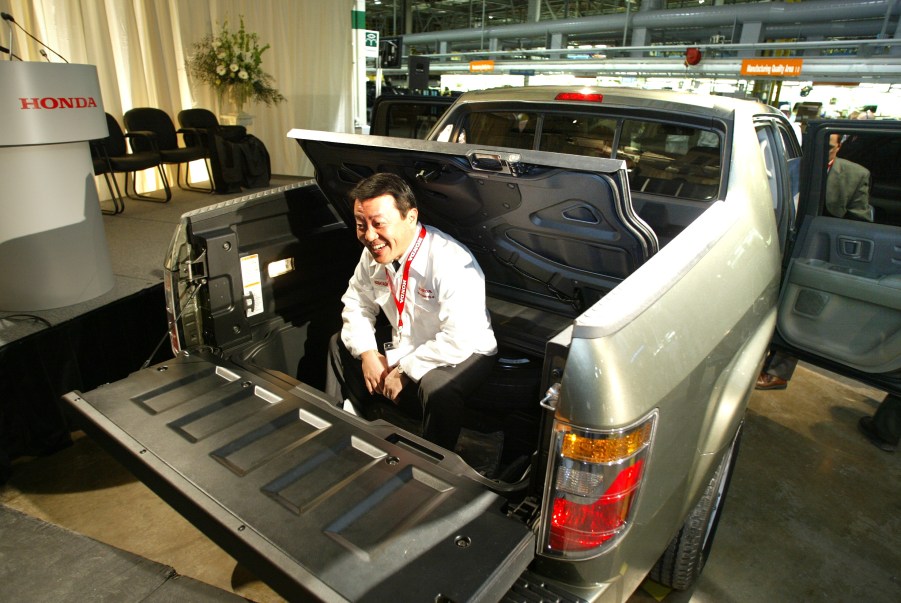 A man sits in the bed of the Honda Ridgeline pickup truck