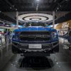 A blue Ford F-150 Raptor on display at an auto show