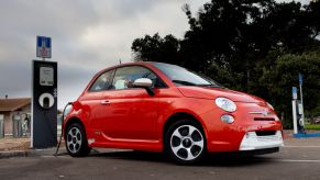 A red Fiat 500e plugged in and charging