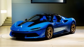 A blue, ultra rare Ferrari J50 on a showroom floor.