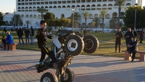 A Libyan boy performs a wheelstand ("wheelie") maneuver with an all-terrain vehicle (ATV) at a park in the capital Tripoli near the Martyrs' Square