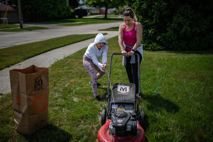 Two people trying to start a lawn mower, if your lawn mower won't start, there's likely a reason why