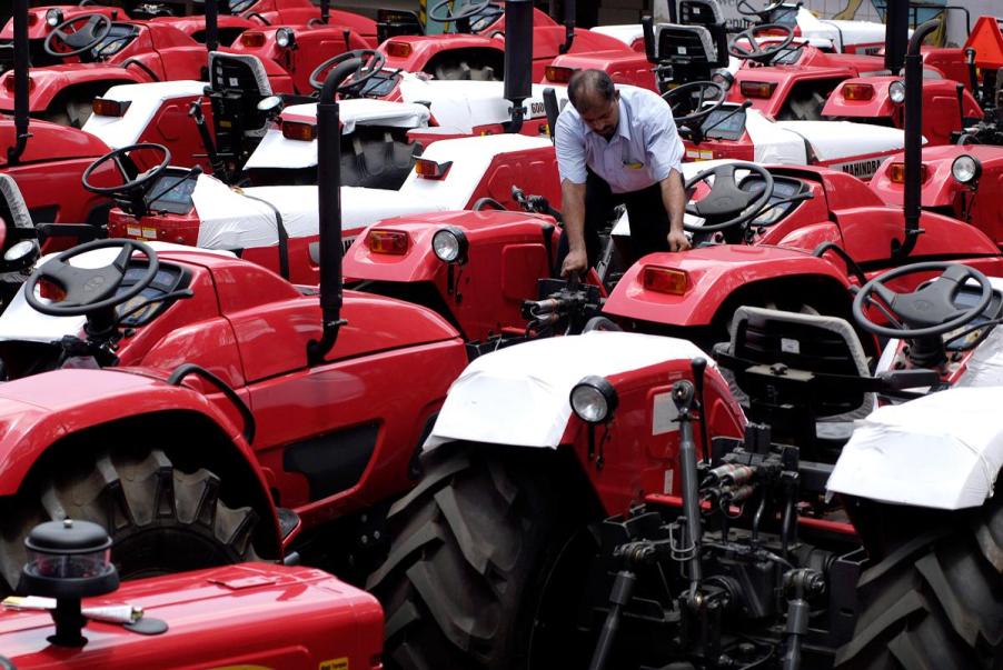 A person working on a Mahindra tractor.