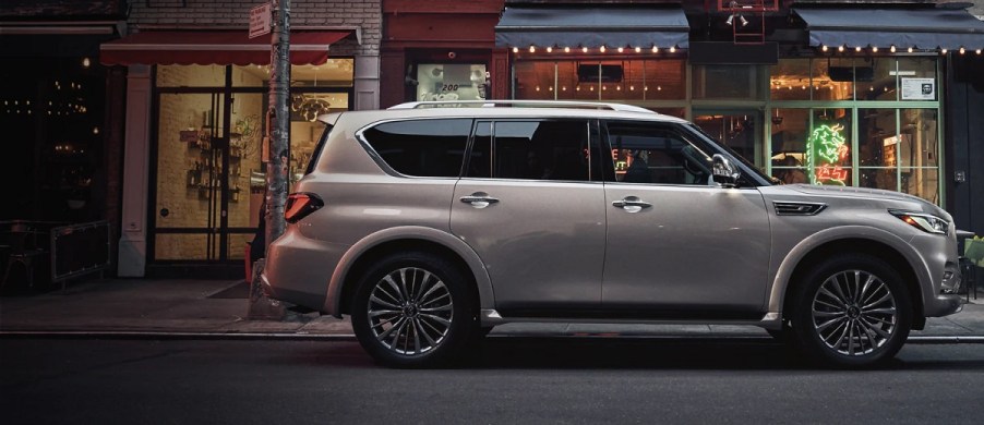 A gold 2021 Infiniti QX80 sitting outside of a store.