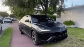 An image of a Lamborghini Urus parked on a sidewalk.