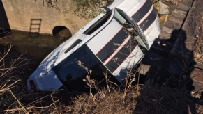 An image of a crashed Ford Mustang outdoors.