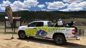 The Stay the Trail truck and dirt bike parked in the dirt to help ATV and dirt bikers learn the OHV rules