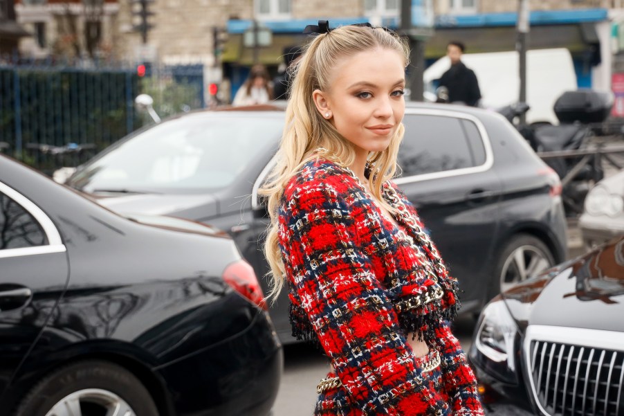 Sydney Sweeney wears a red Balmain tweed jacket and skirt in February 2020 in Paris, France