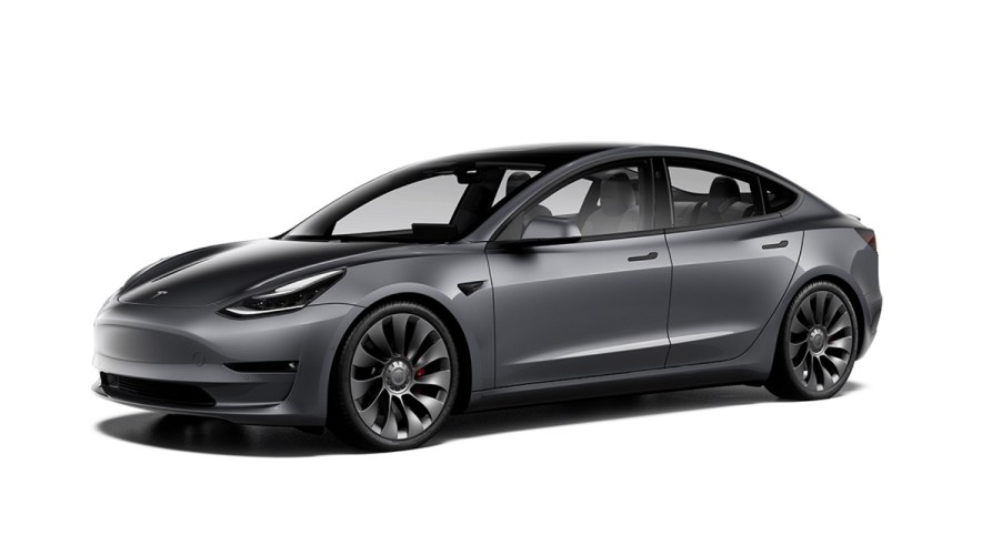 A dark gray Tesla model 3 against a white background.