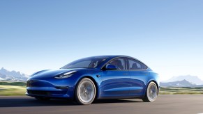 A blue Tesla Model 3 small electric sedan.