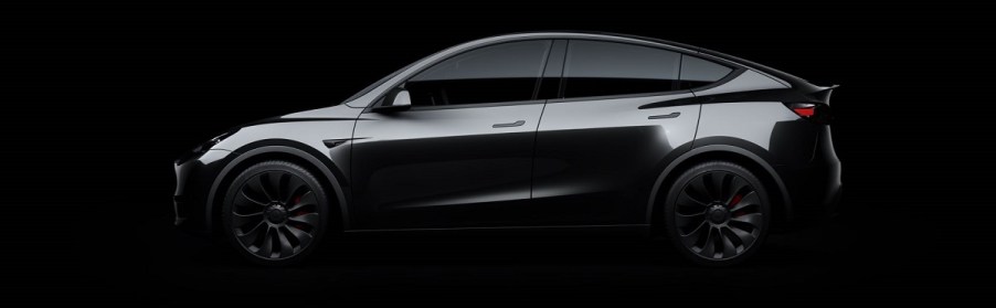 A dark gray 2021 Tesla Model Y against a black background.