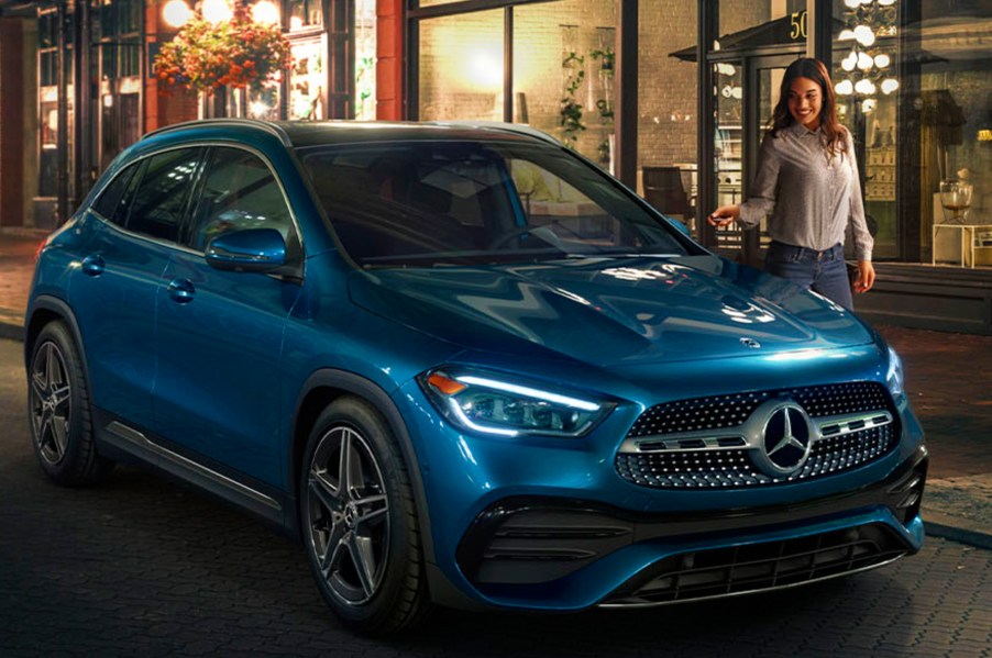 a light blue 2021 mercedes-benz GLA-Class on the curb of a fashionable night time cityscape