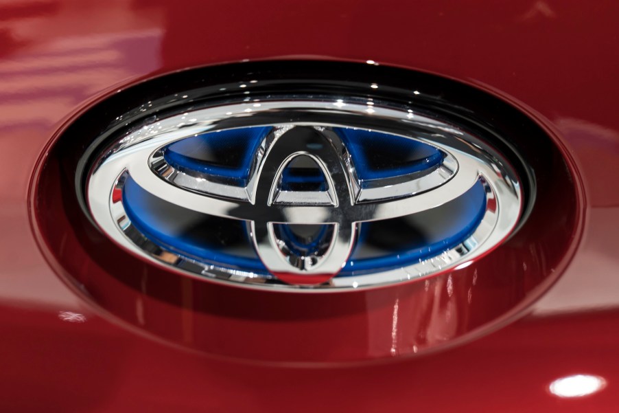 A close-up of a silver Toyota logo on the front of a red vehicle