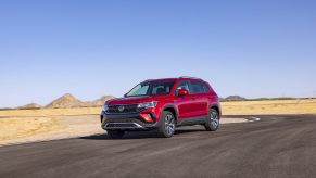 The red 2022 Volkswagen Taos driving along a desert road