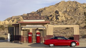 A red GM EV1 electric car parked at a rural gas station in April 1997