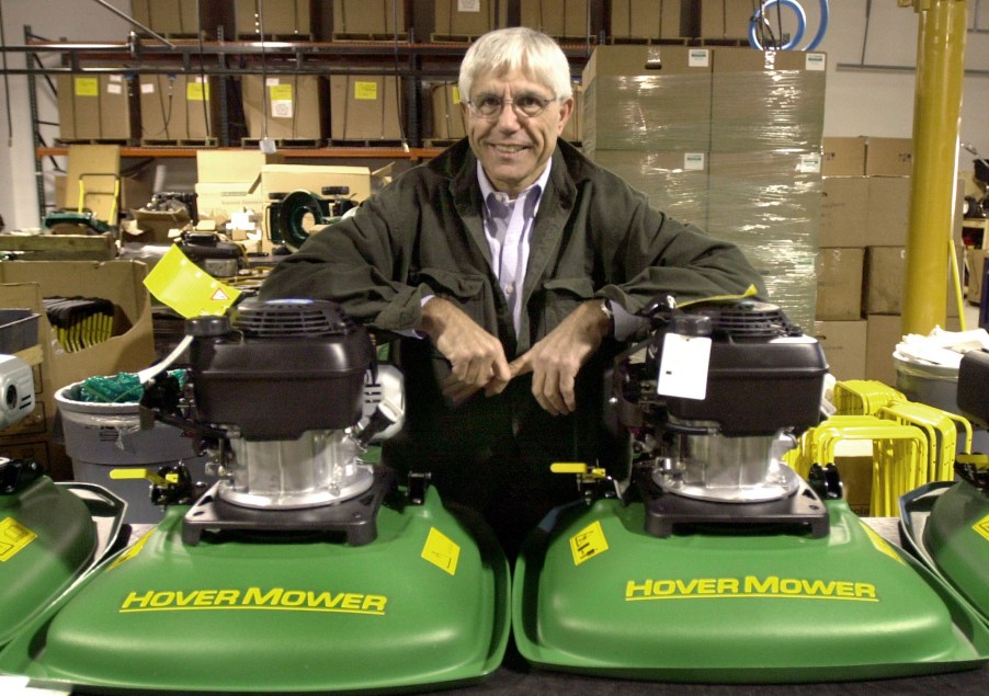 Nick Nikazmerad, president of Eastman Industries, leans on two hover lawn mowers in December 2004