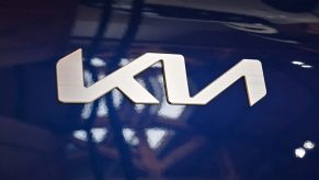 A silver Kia logo emblem on a blue EV6