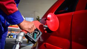 A man pumping gas into a car at a gas station