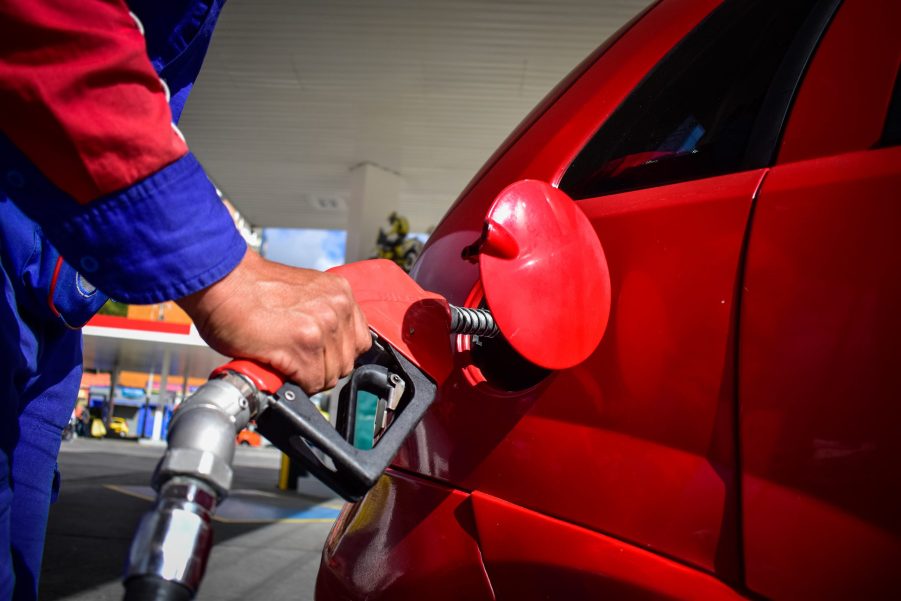 A man pumping gas into a car at a gas station