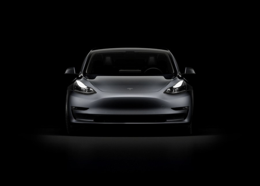 A dark gray Tesla Model 3 against a black background. The Tesla Model 3 police car is ready to be trialed in the U.K.