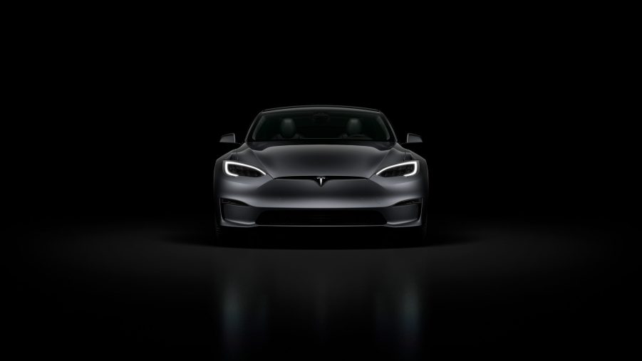 A black Tesla Model S Plaid in a black room