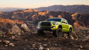 The 2022 Toyota Tacoma TRD Pro in Electric Lime climbing over rocks