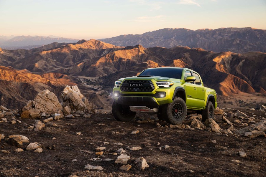 The 2022 Toyota Tacoma TRD Pro in Electric Lime climbing over rocks