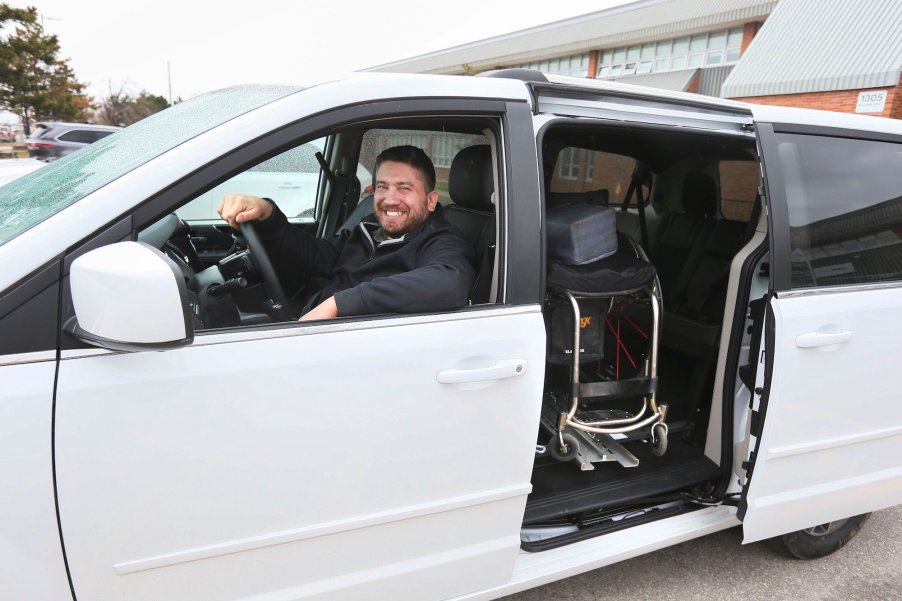 Teaching assistant Ryan Leworthy poses with his vehicle's wheelchair lift, paid for by an anonymous donor, in March 2016