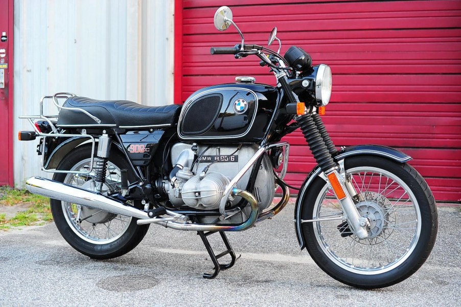 A black 1975 R90/6 in front of a red garage door