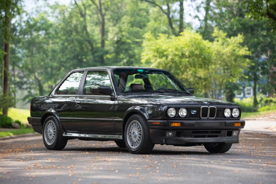 A black 1991 BMW 325iX on a tree-lined road