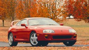 A red 1994 Toyota Supra among the fall leaves