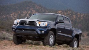 A navy 2013 Toyota Tacoma in the wilderness, the 2013 Toyota Tacoma is one of the best used compact trucks under $20,000