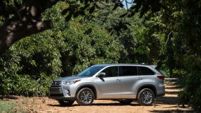 A silver 2017 Toyota Highlander parked amongst trees, the 2017 Toyota Highlander is the best CPO three-row SUV under $30,000