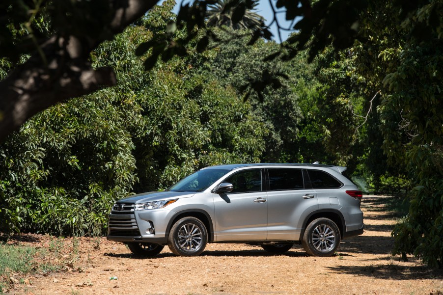 A silver 2017 Toyota Highlander parked amongst trees, the 2017 Toyota Highlander is the best CPO three-row SUV under $30,000