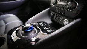 A 2019 Nissan Leaf's center console showing a gear shifter and other controls. The Leaf is vegan-friendly.