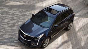 An aerial view of a black 2021 Cadillac XT5 on a grey brick driveway.