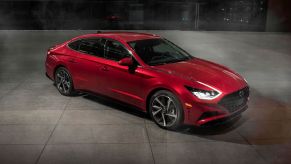 A red 2021 Hyundai Sonata sedan parked on a empty building floor of tiles at night