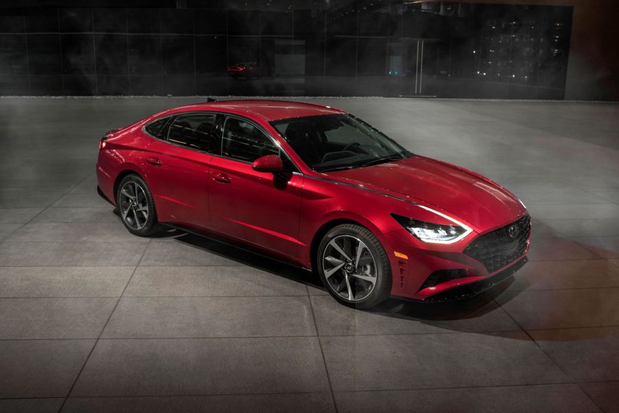 A red 2021 Hyundai Sonata sedan parked on a empty building floor of tiles at night